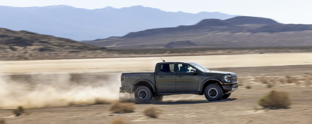 Ford ranger raptor driving with dust behind it